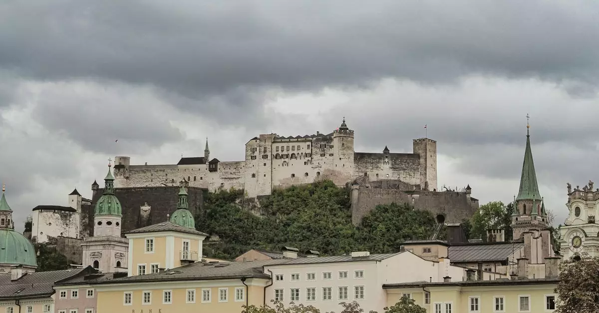 Scenic view of Hohensalzburg Fortress atop a hill in Salzburg, Austria on a cloudy day.
