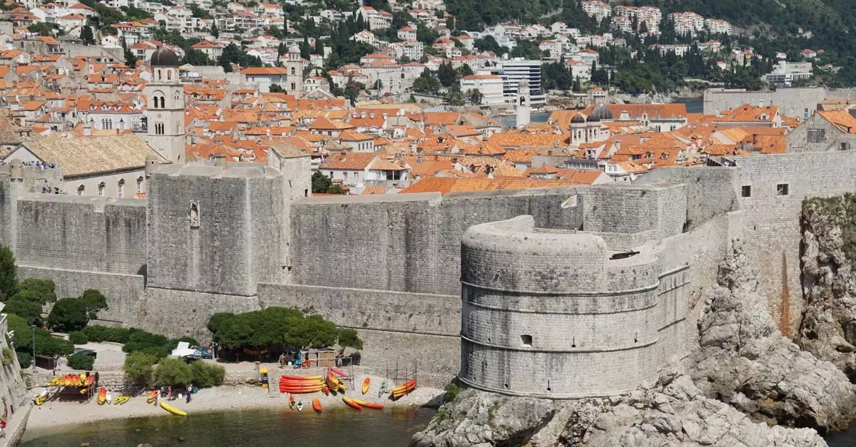Scenic view of Dubrovnik's historic stone walls and coastline, showcasing medieval architecture.