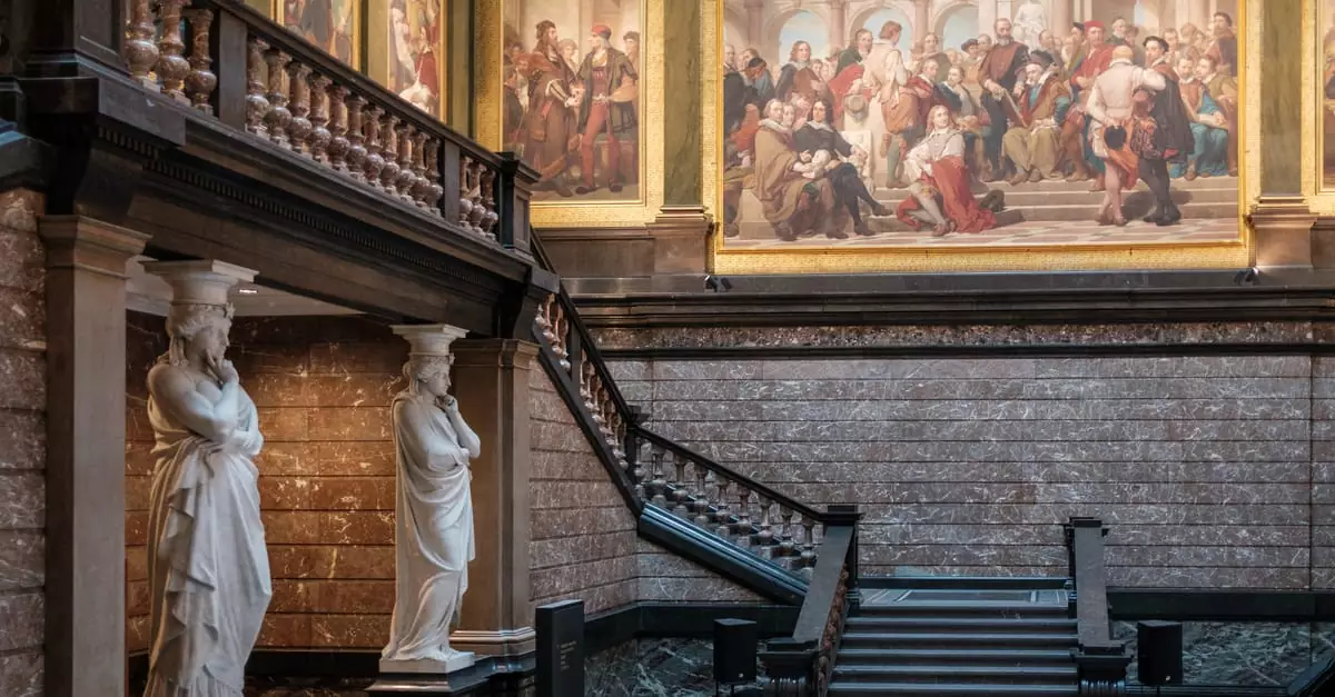 Elegant museum interior showcasing classical statues and grand staircase leading to large historical paintings.