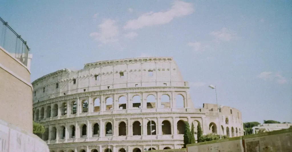 View of the iconic Colosseum in Rome, Italy, on a sunny day with tourists exploring the landmark.