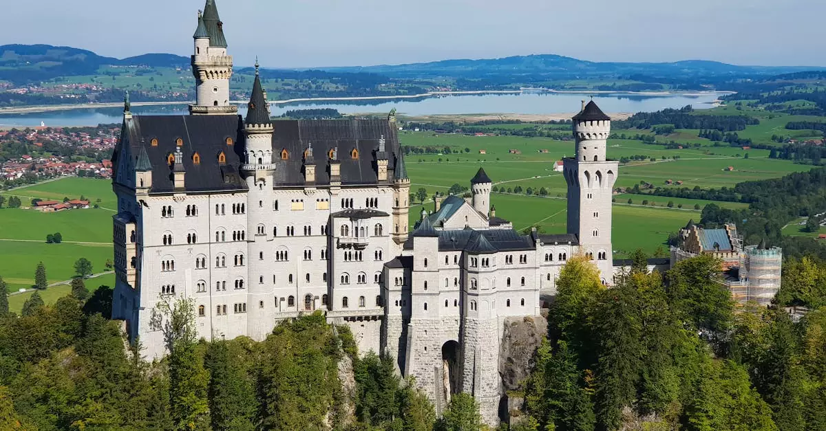 Stunning aerial view of Neuschwanstein Castle surrounded by lush greenery in Bavaria, Germany.