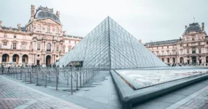 Iconic Louvre Pyramid in Paris, showcasing classic and modern architecture.