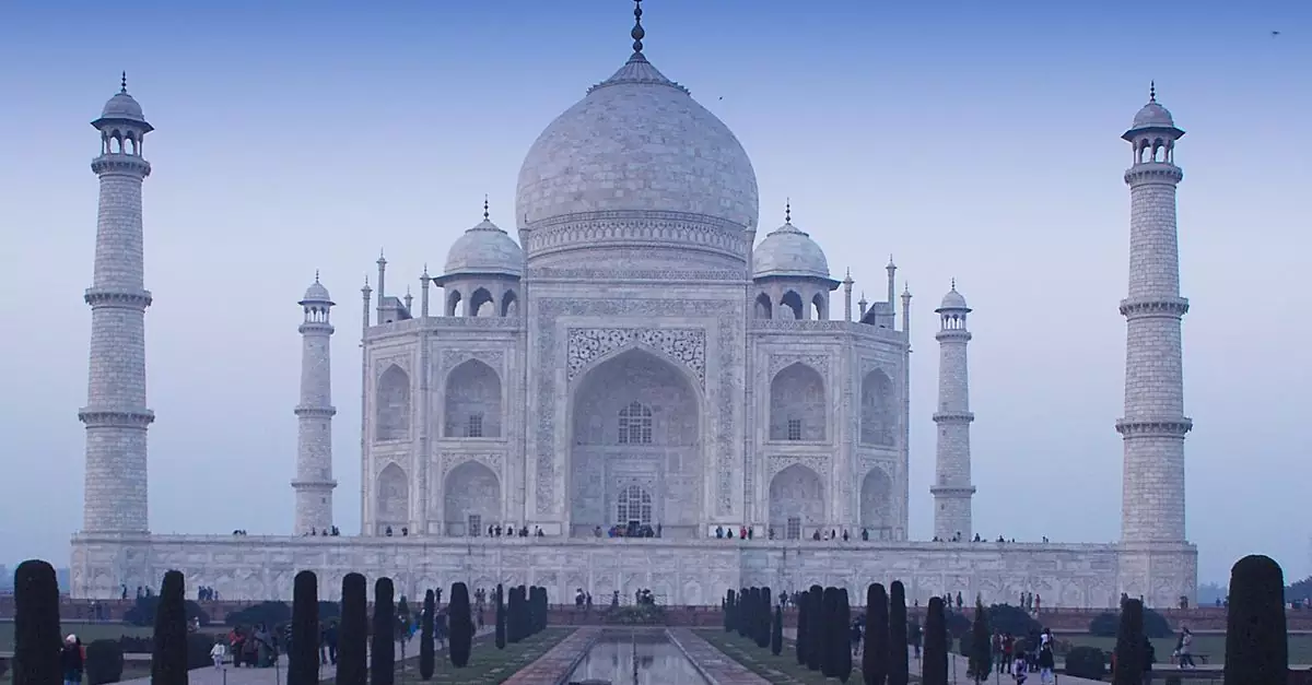 Stunning photo of the iconic Taj Mahal with its reflection at twilight, showcasing Mughal architecture.
