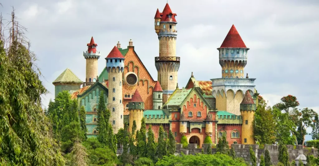Best Folklore Destinations in South America for 2026 8 A vibrant fairytale castle surrounded by lush greenery and dramatic clouds in Lemery, Philippines.