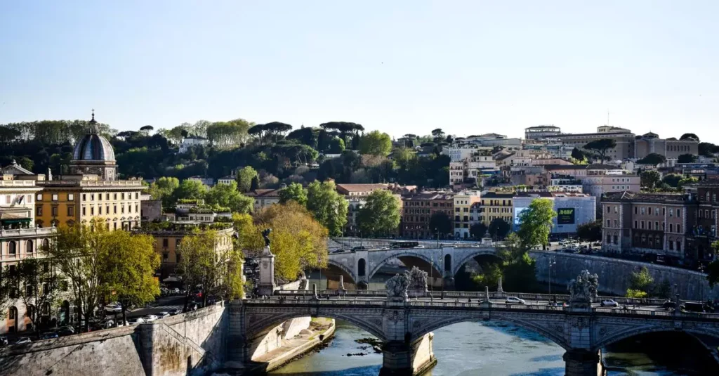 Beautiful view of Ponte Sant'Angelo spanning the Tiber River in Rome, Italy under a clear sky.