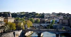 Beautiful view of Ponte Sant'Angelo spanning the Tiber River in Rome, Italy under a clear sky.