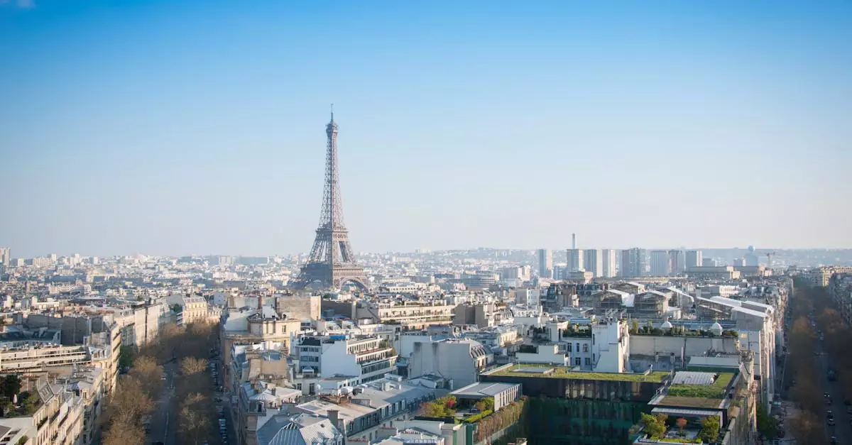 A stunning aerial view of Paris with the iconic Eiffel Tower and cityscape under a clear blue sky.