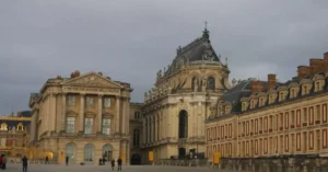 Historic Versailles Palace showcasing classic French architecture under a cloudy sky.