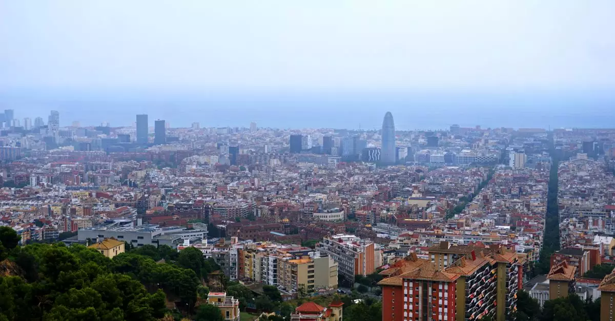 A breathtaking aerial view of Barcelona's cityscape featuring the skyline and Mediterranean Sea in the background.