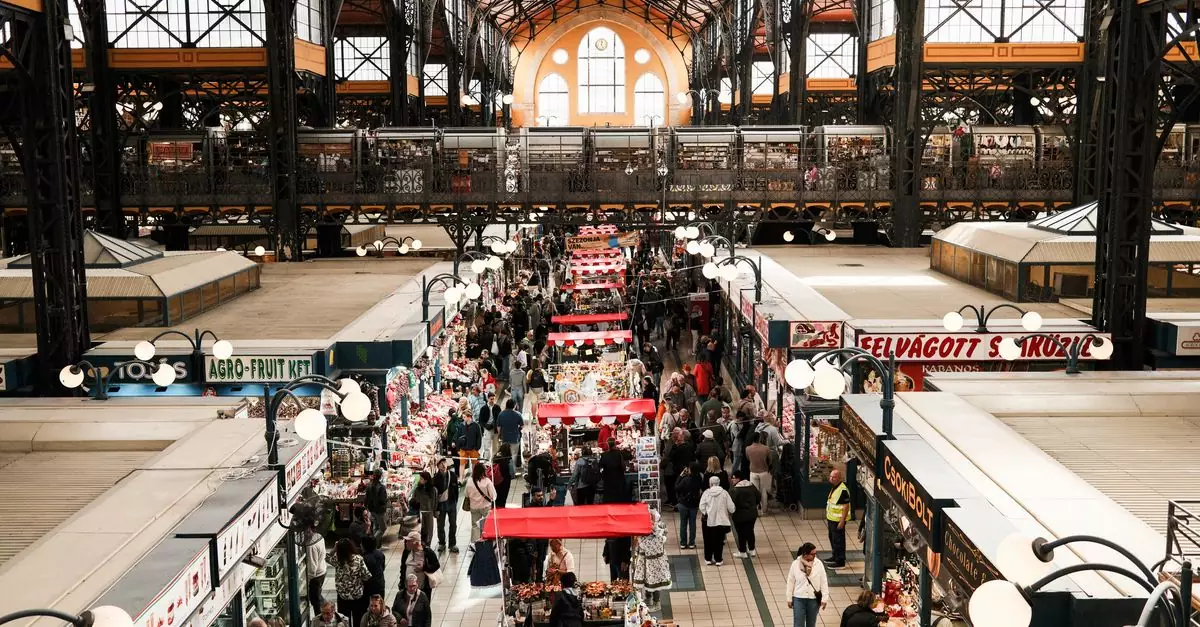 Explore the vibrant Budapest Central Market Hall filled with shoppers and vendors captured from above.