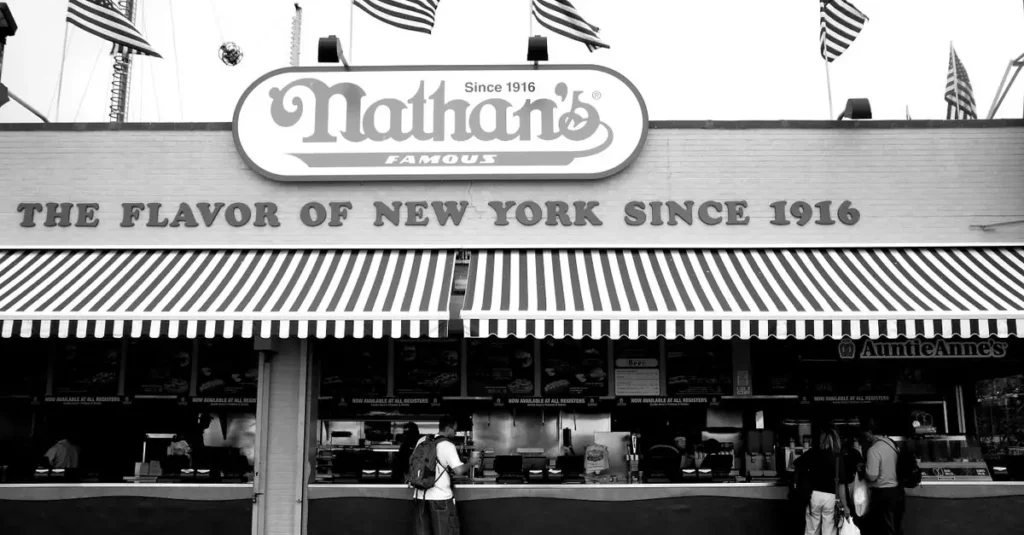 Best Food Tourism Destinations in South America 2026 2 Black and white photo of Nathan's Famous, a New York City icon, with American flags.