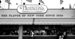 Black and white photo of Nathan's Famous, a New York City icon, with American flags.