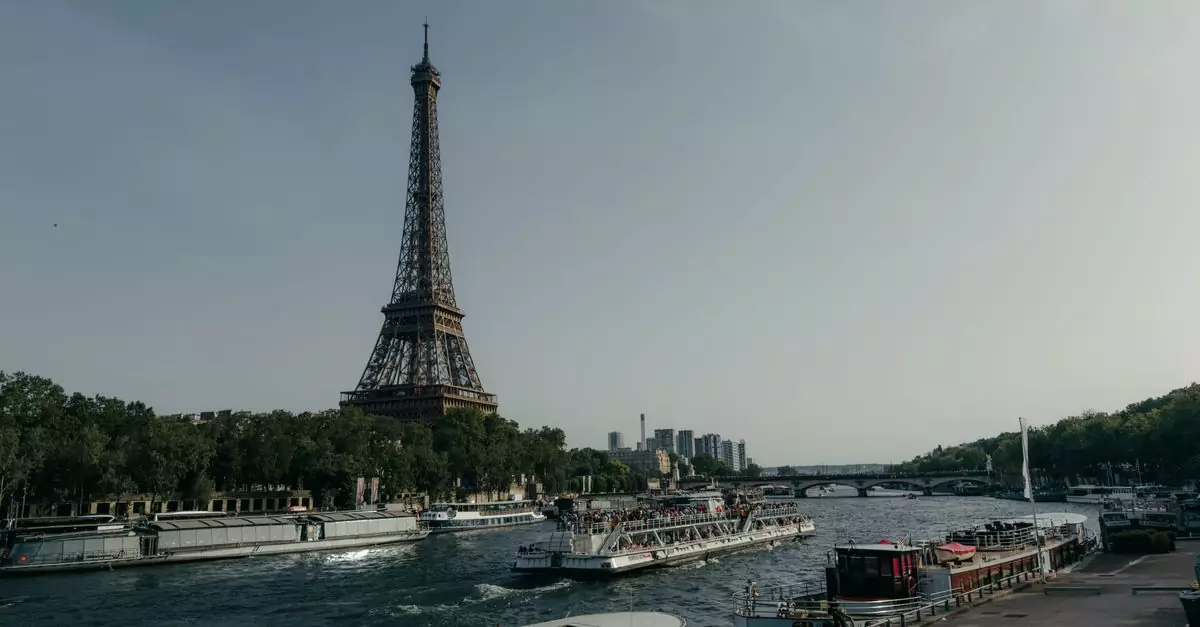 Scenic view of the Eiffel Tower and boats on the Seine River in Paris during the day.