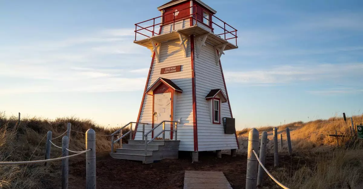 Charming Covehead Harbour Lighthouse surrounded by nature at sunset in Prince Edward Island, Canada.