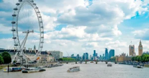 Capture of London's iconic skyline featuring the London Eye, Big Ben, and River Thames on a sunny day.
