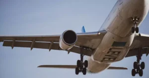 Close-up of a commercial airplane in flight preparing for landing against a clear blue sky.