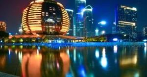 Stunning reflection of Hangzhou's illuminated skyline featuring modern architecture during the night.
