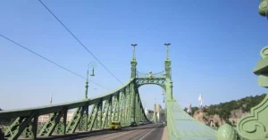 Capture of the iconic Liberty Bridge in Budapest, Hungary, under a clear blue sky.