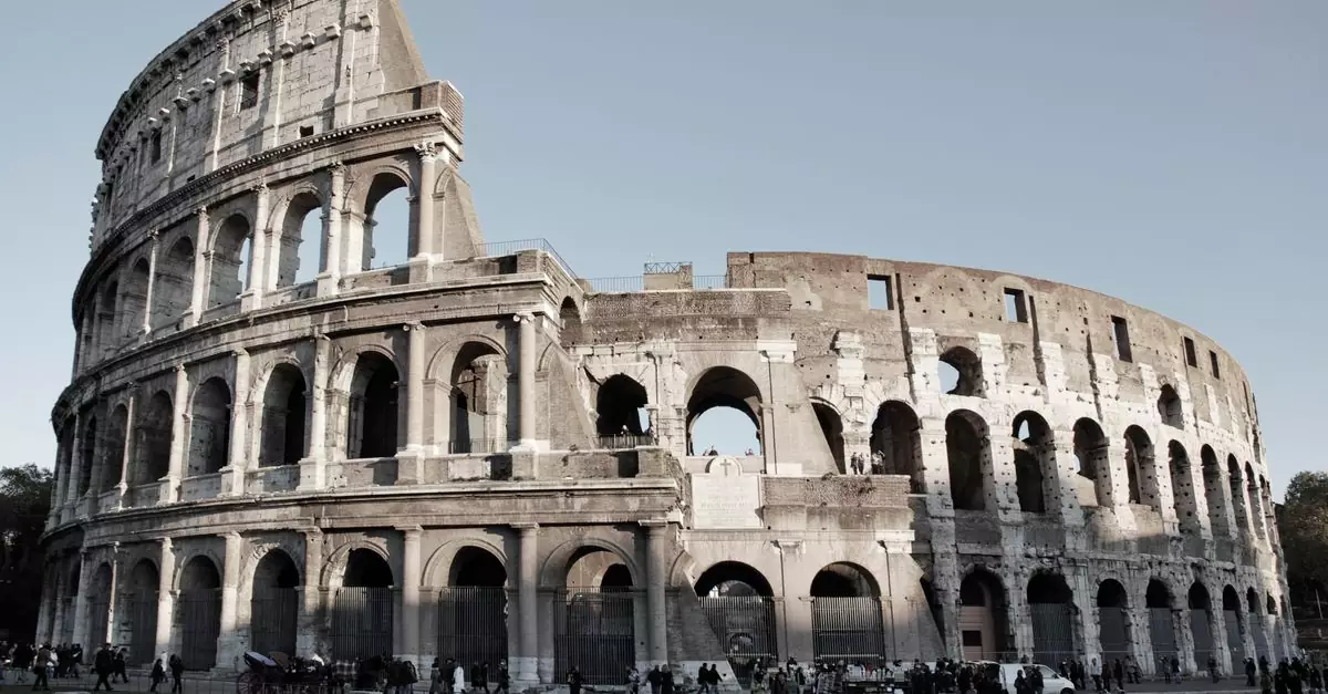 Explore the grandeur of the ancient Roman Colosseum in Rome, Italy, under a clear sky.