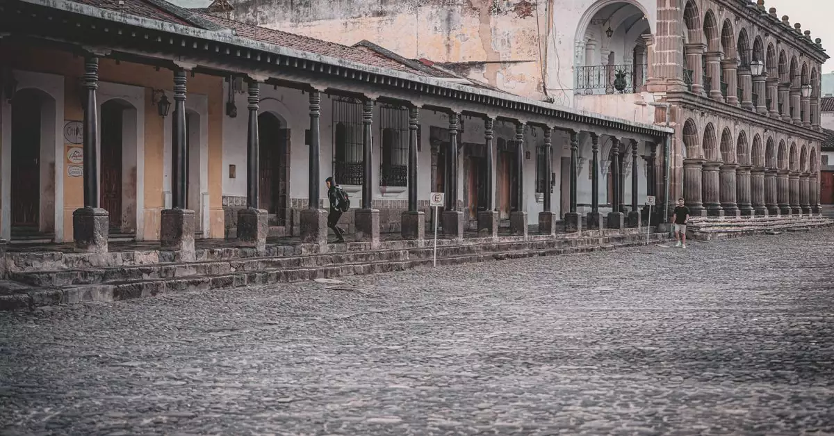 Elegant colonial buildings with stone archways and cobblestone streets in Antigua Guatemala.