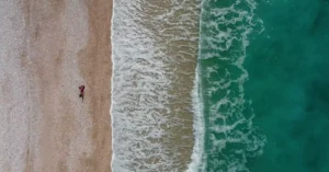 Explore the stunning aerial view of Borsh Beach, Albania with waves crashing on the shore.