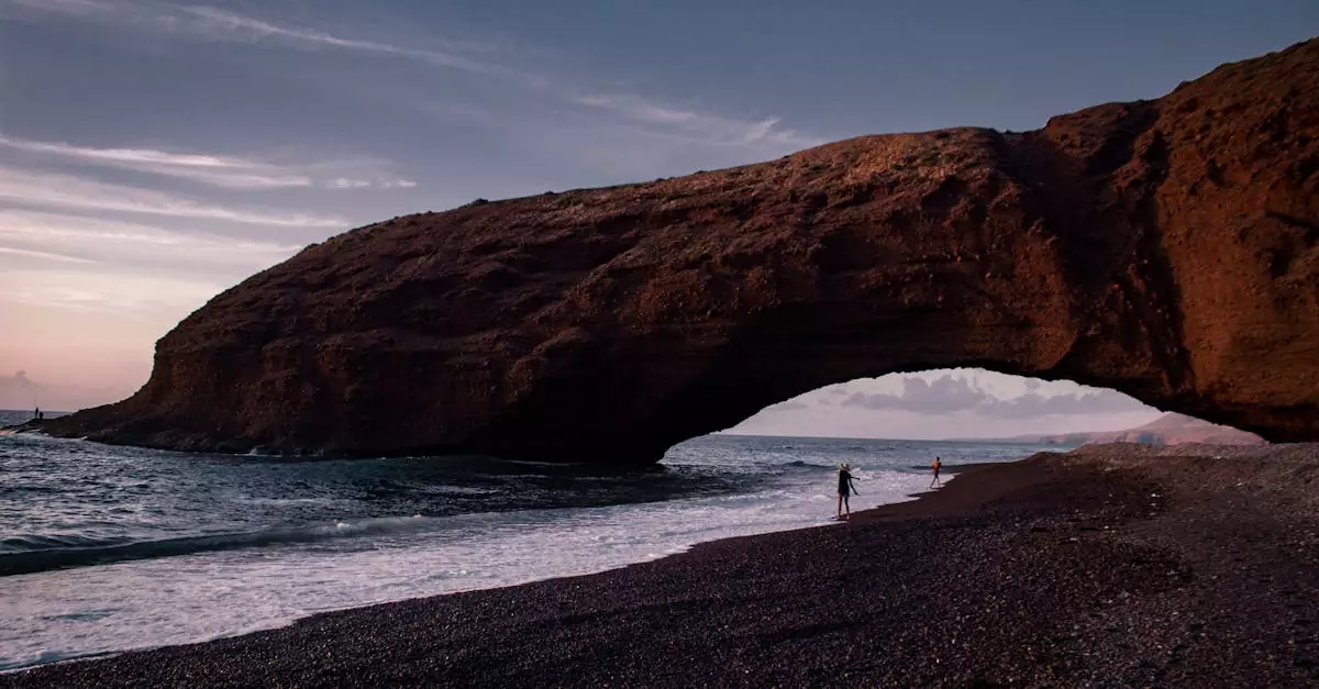 Beautiful view of the natural arch at Lagzira Beach in Morocco during sunset with the ocean waves and scenic coastline.