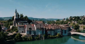 Aerial view of historic Laufenburg, Switzerland, featuring architectural charm along the Rhine River under a clear summer sky.