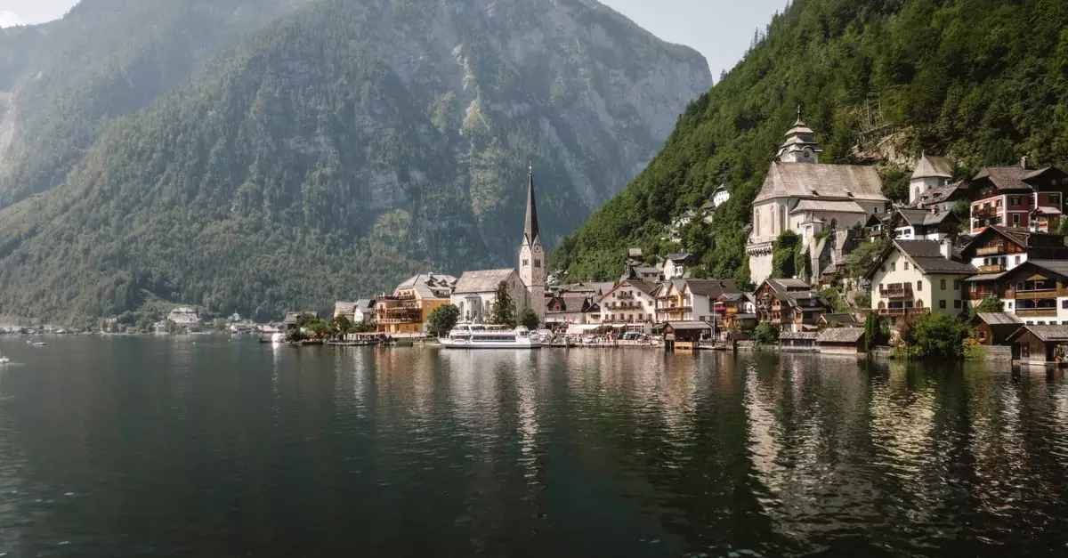Serene view of Hallstatt village nestled by the lake, with mountains in the background.