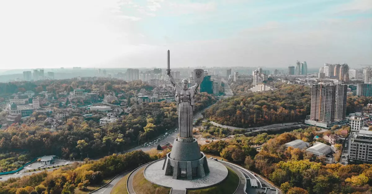 Drone capture of Motherland Monument, featuring Kyiv's cityscape in the background on a clear day
