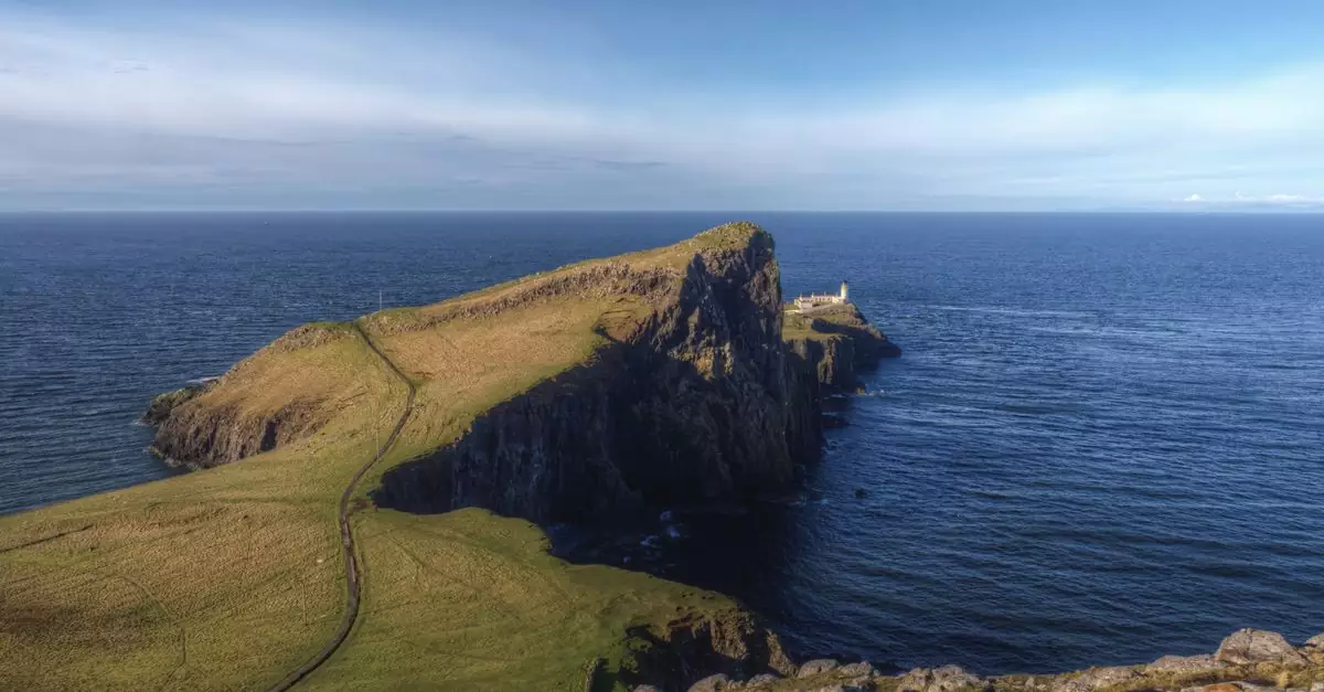 A breathtaking view of the Neist Point Lighthouse on the Isle of Skye, surrounded by ocean.