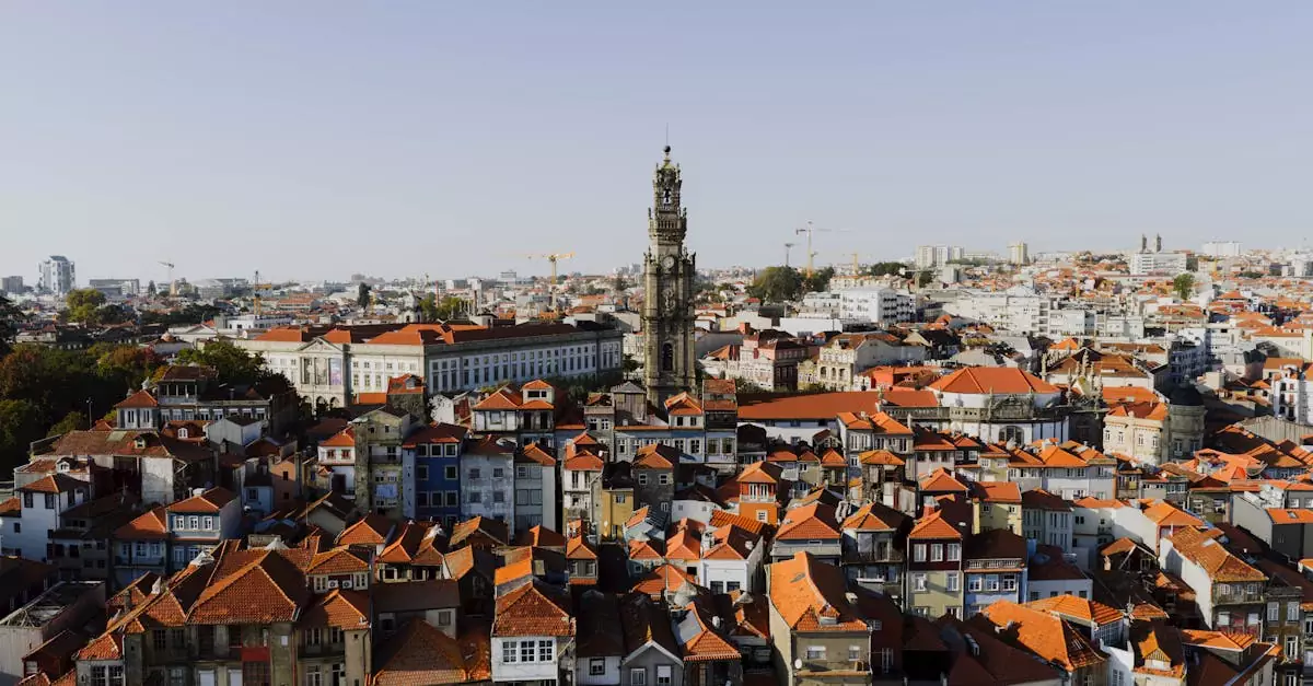 A beautiful aerial view of Porto, Portugal, highlighting the iconic Clerigos Tower at sunset.