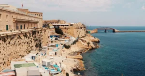 Explore the stunning cliffside and azure waters of Valletta, Malta, showcasing its rich urban landscape.