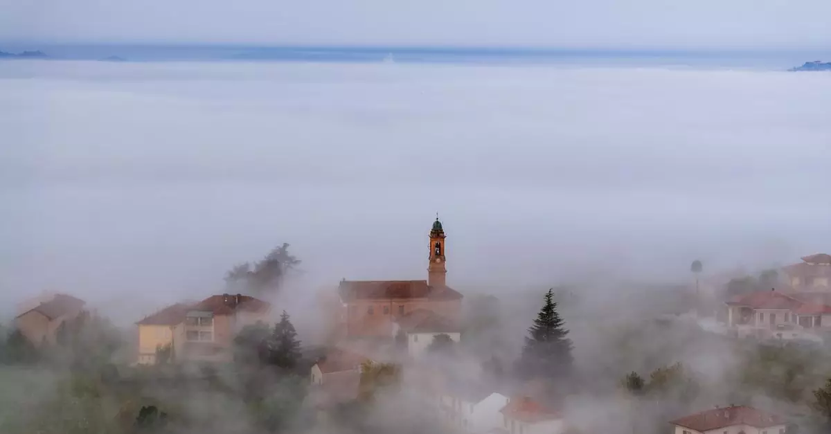 A foggy aerial view of the picturesque town of Annunziata, Piemonte, Italy.