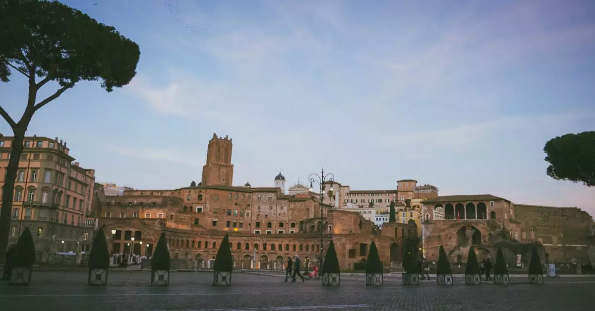 View of historic Roman ruins at twilight with cobblestone streets and trees.
