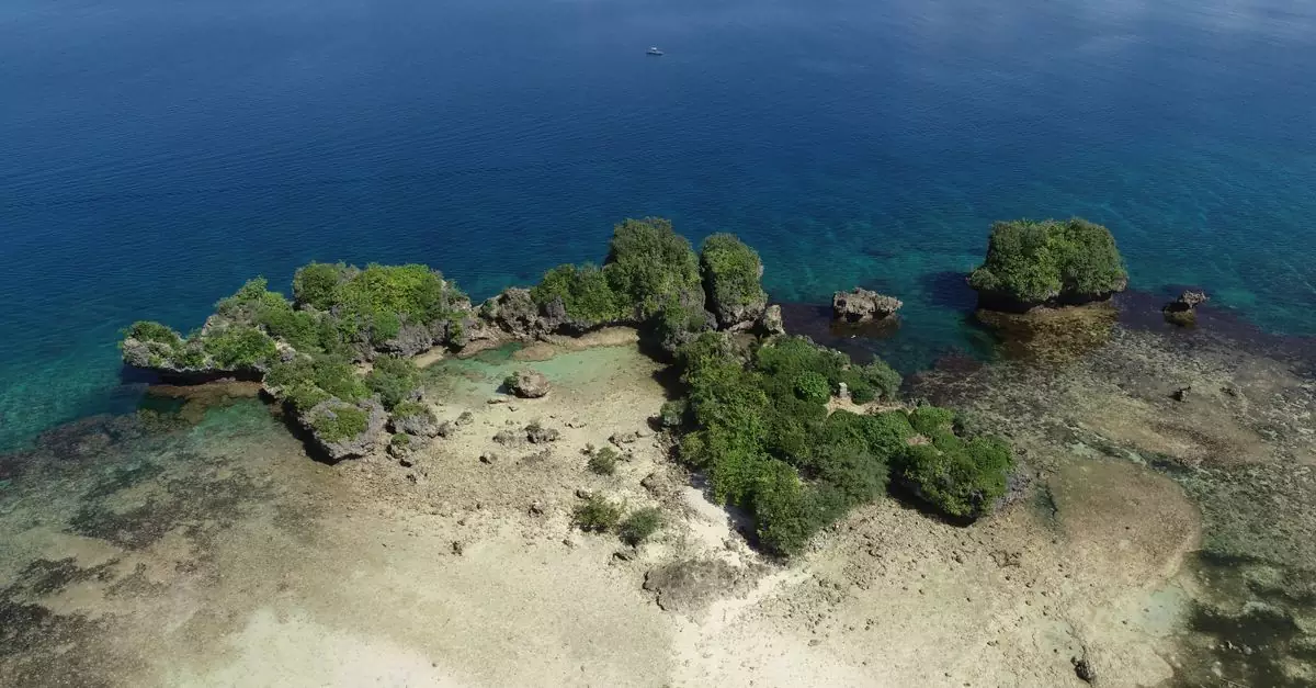 Stunning aerial shot of a hidden lagoon with lush greenery and rocky formations in Sorsogon City, Philippines.