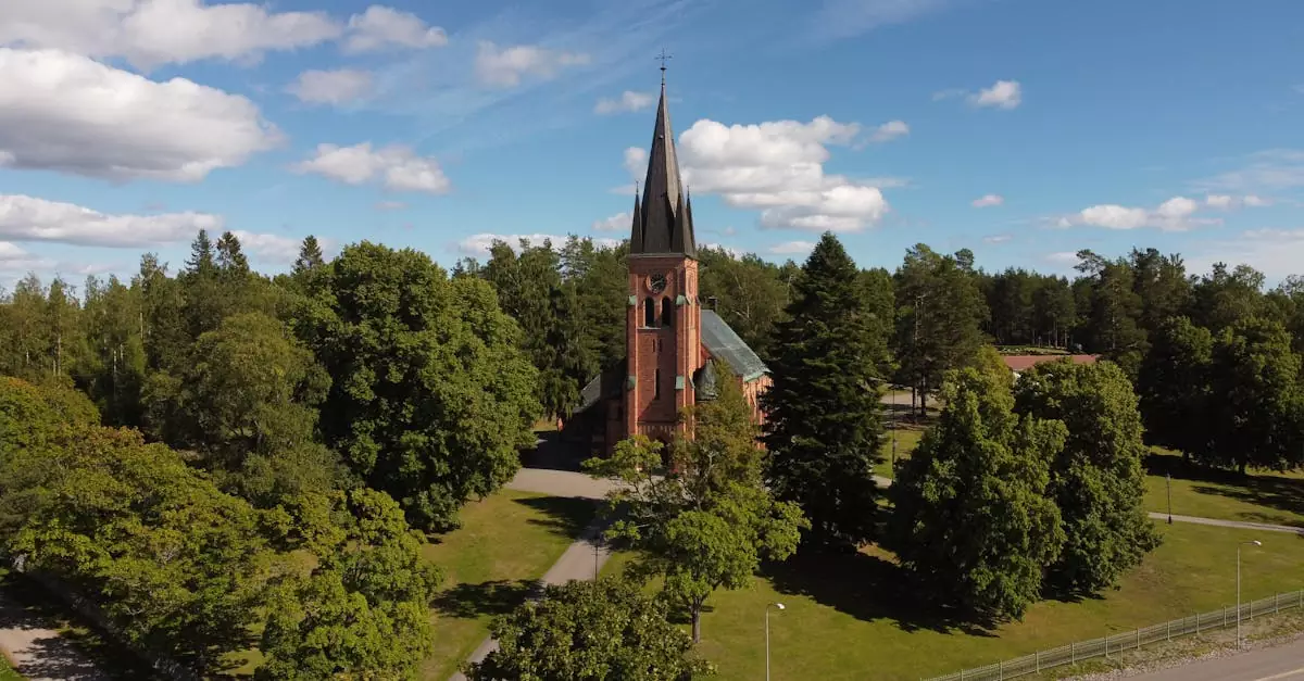 Explore the picturesque Alnö Church surrounded by lush greenery on a sunny summer day in Sweden.
