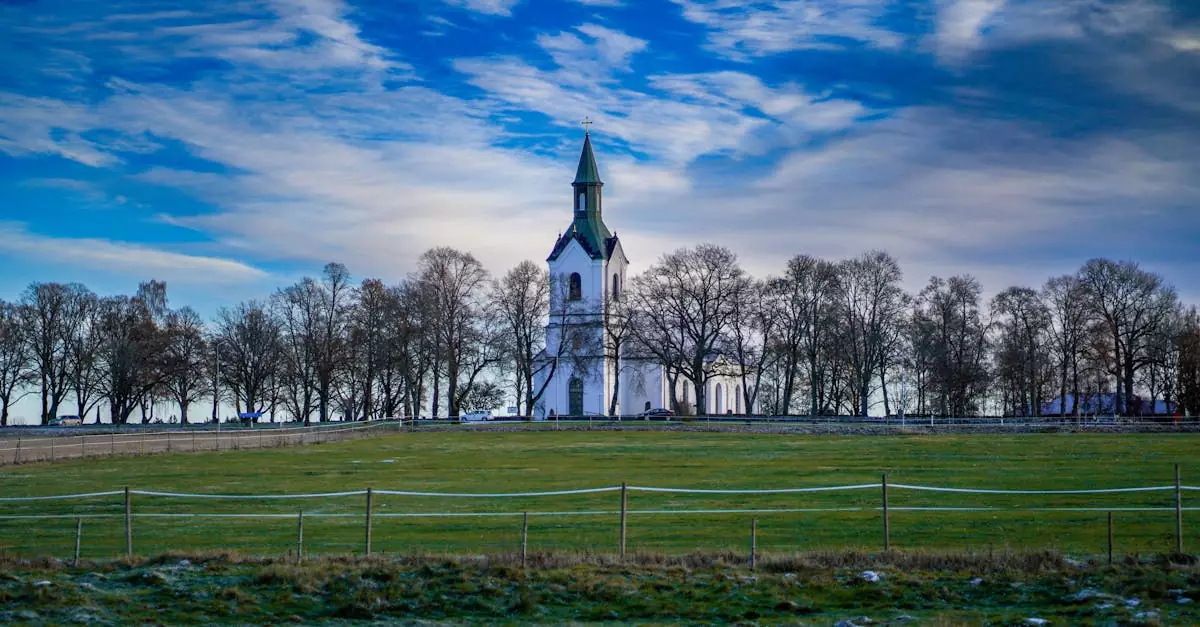 A scenic view of Rogberga Church surrounded by barren trees in the Swedish countryside.