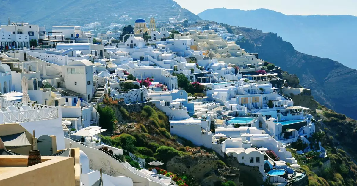 A stunning landscape of Santorini, Greece, featuring white buildings and blue domes against the Aegean Sea.
