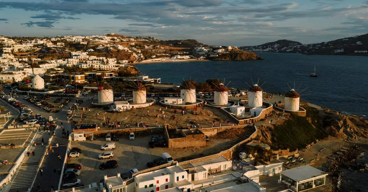 Captivating view of Mykonos windmills overlooking the Aegean Sea, highlighted by a beautiful sunset.