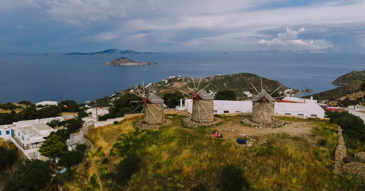 Aerial view of traditional windmills on Patmos Island in Greece with sea and hills.