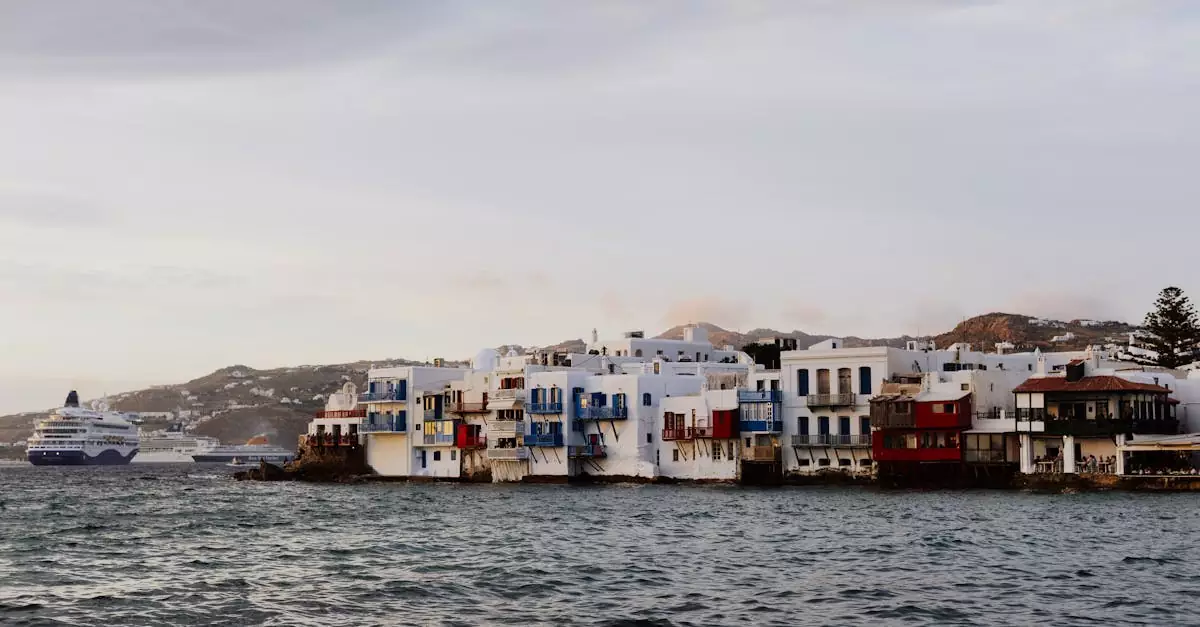 Charming seaside view of the iconic Little Venice in Mykonos, Greece with a cruise ship in the background.