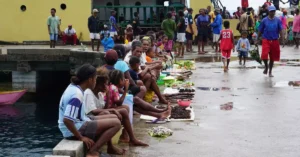 A bustling market scene with locals selling food and goods in Papua, Indonesia.