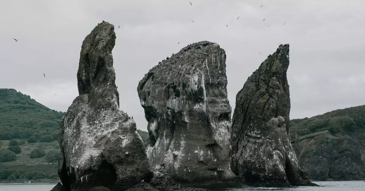 Stunning view of the Tri Brata rock formations in Kamchatka, surrounded by ocean and natural beauty.