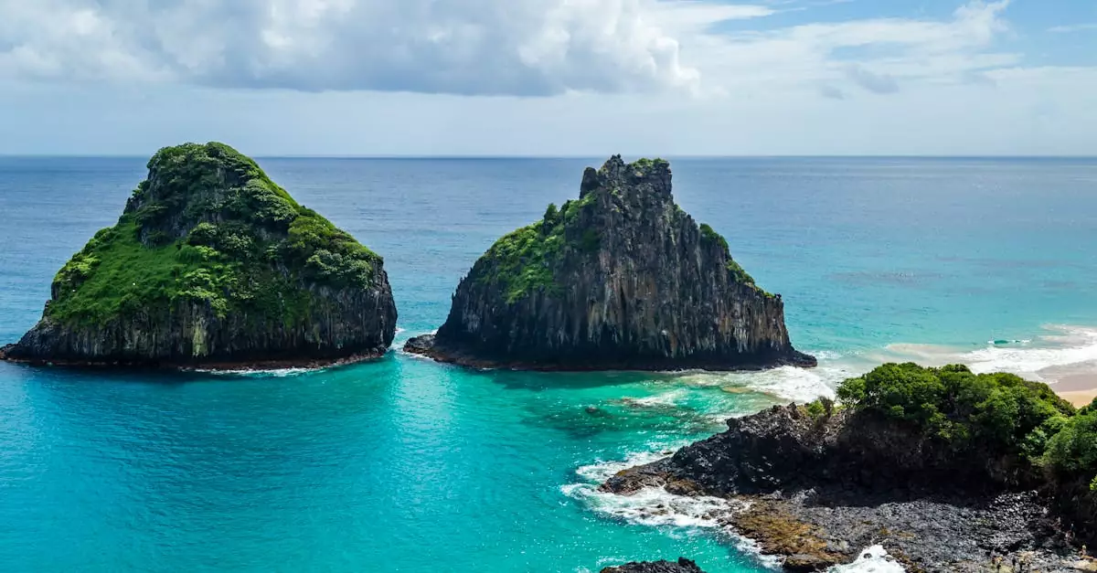 A breathtaking view of the Two Brothers Rock formations in turquoise waters at Fernando de Noronha, Brazil.