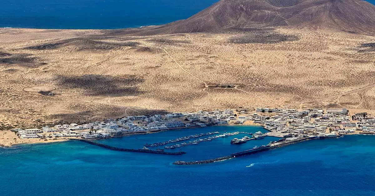 Stunning aerial shot of Lanzarote's coastal harbor and arid landscape under clear skies.