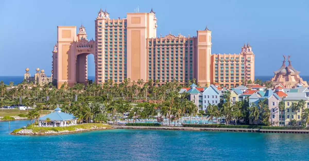 Scenic view of the Atlantis Resort amidst palm trees and blue ocean, Nassau, Bahamas.