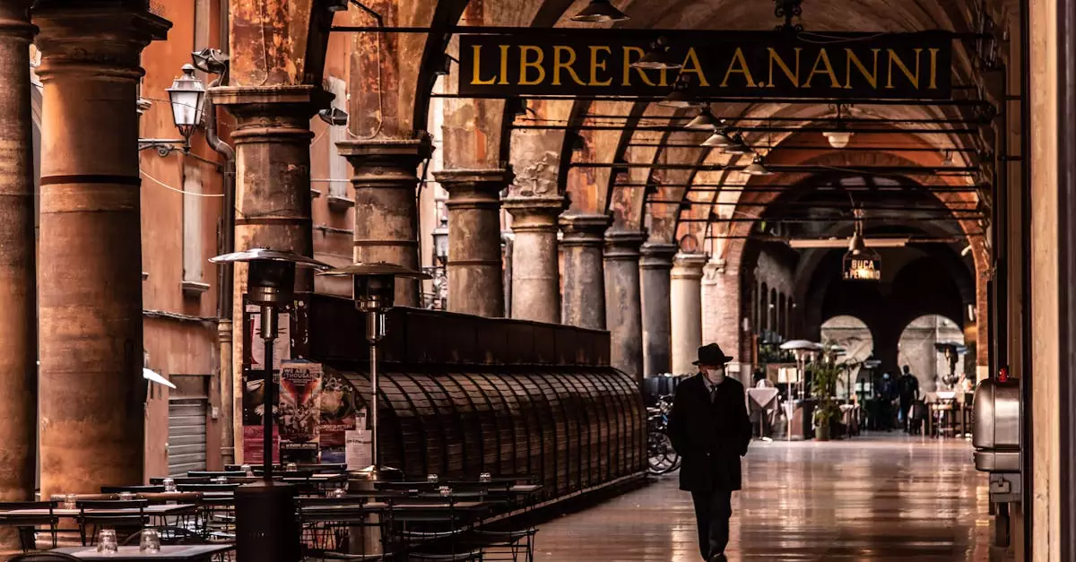 A man walks under the arches of Bologna's historic portico, Italy.