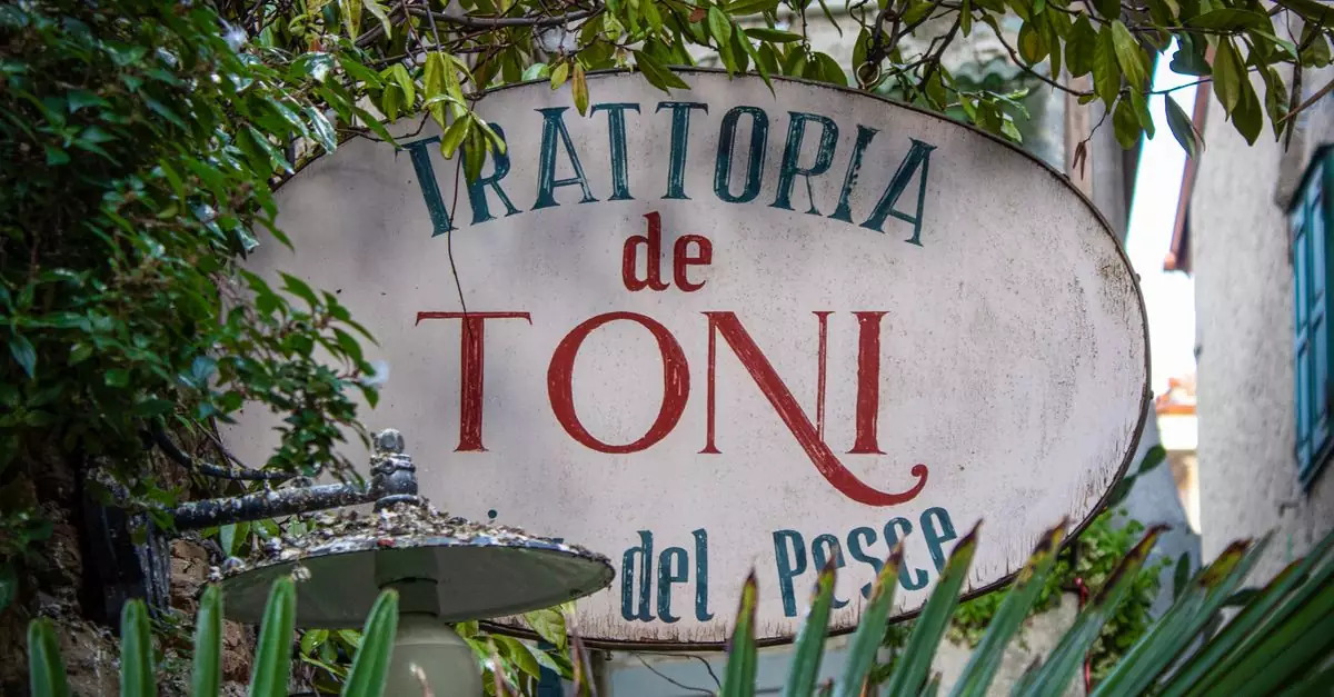 Authentic outdoor sign of Trattoria de Toni in Grado, Italy