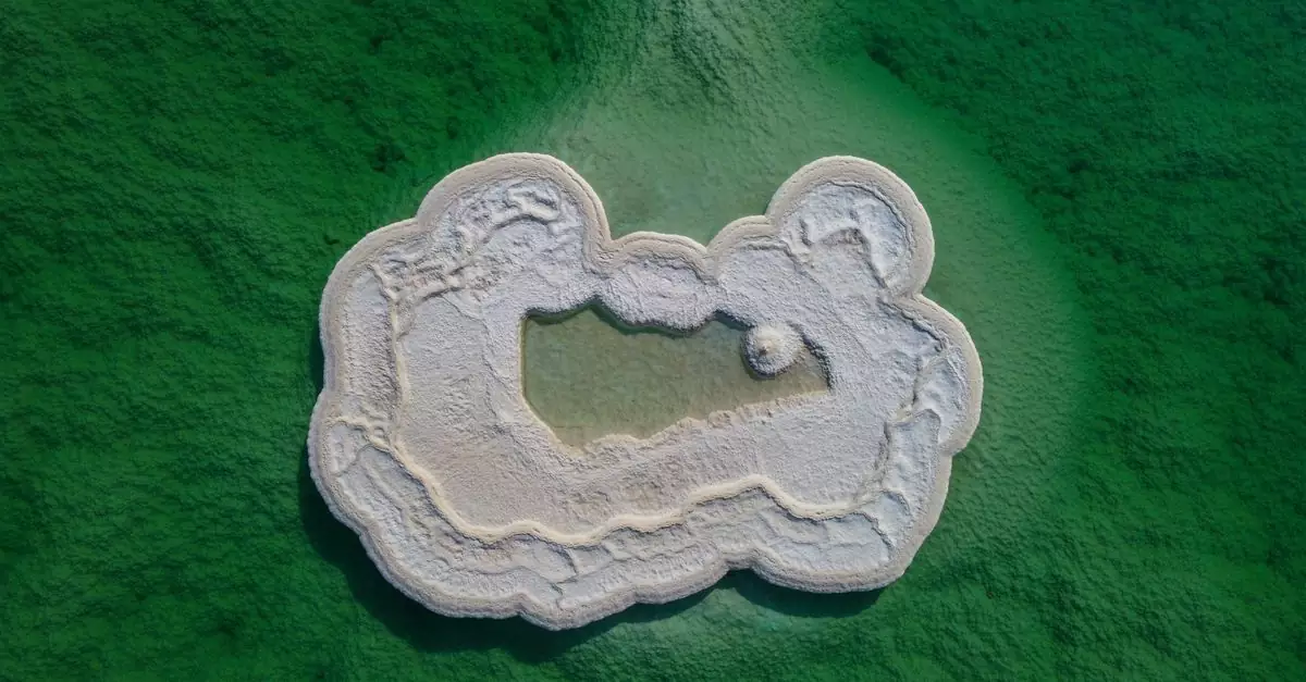 Stunning aerial shot of a white salt island in a vivid green water setting.
