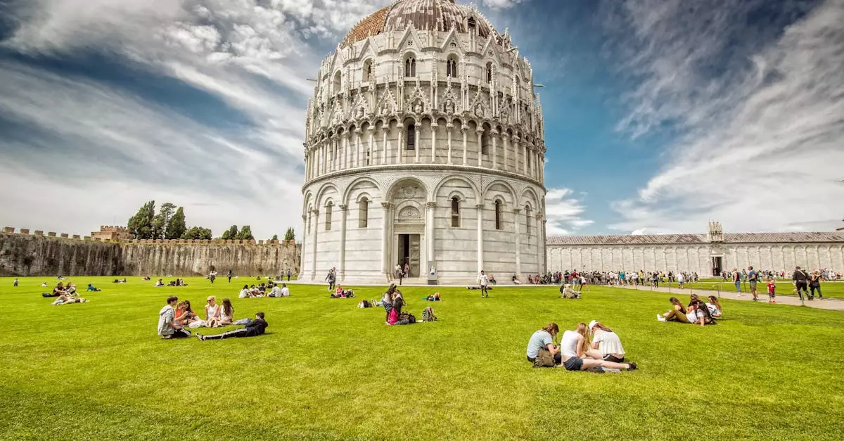 A vibrant scene at Pisa Baptistery with people enjoying the lush green surroundings under a bright sky.